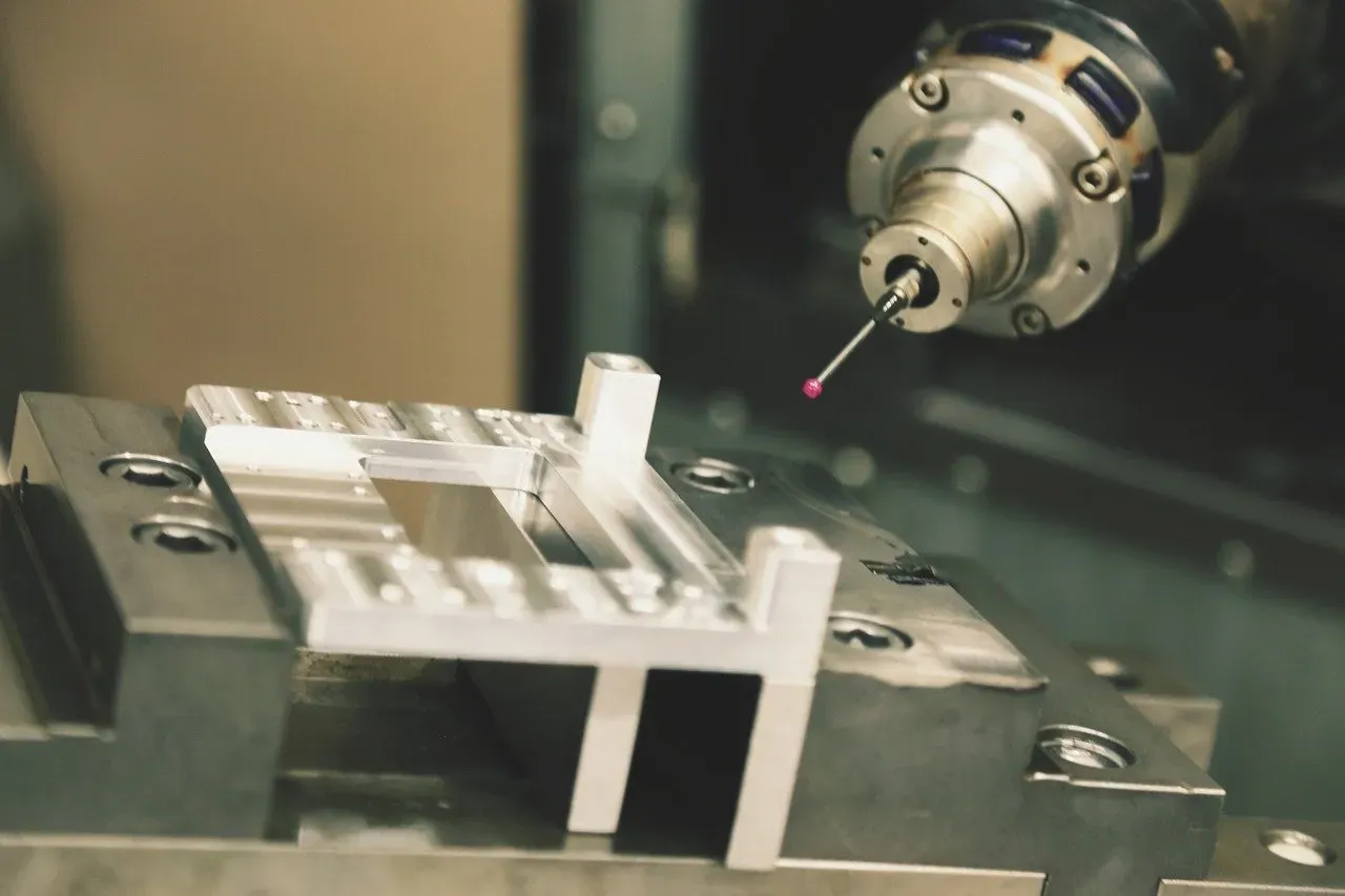 Meettaster controleert een gefreesd aluminium werkstuk in een CNC-machine